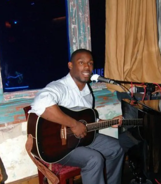 Joshua Johnson playing guitar and singing